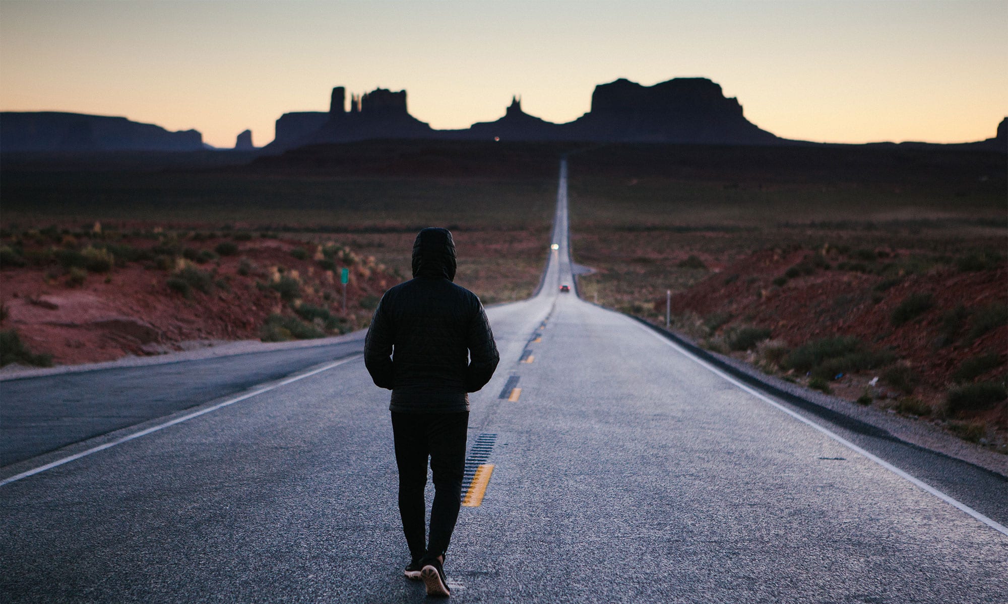 Photo of a person facing a long road ahead.